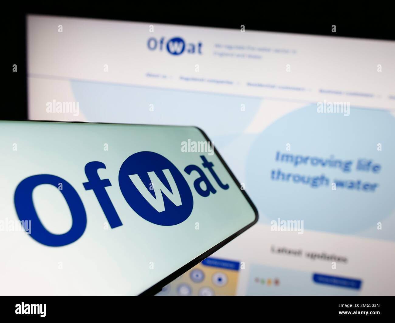 Mobiltelefon mit Logo der Wasserdienstregulierungsbehörde (Ofwat) auf dem Bildschirm vor der Website. Fokus auf die Mitte rechts des Telefondisplays. Stockfoto
