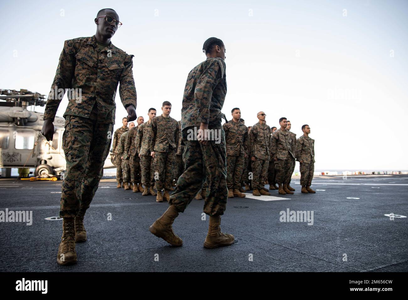 USA Marinekorps CPL. Mujuni Menani, ein Datensystemverwalter, Left, und CPL. Symone White, ein Netzwerkverwalter, rechts, beide mit der 22. Marineexpeditionstruppe, marschieren Sie während einer Wiedereingliederungszeremonie im Rahmen des Commandant's Retention Program (CRP) an Bord eines Amphibienschiffs der Wasp-Klasse USS Kearsarge (LHD 3) im Atlantik, 26. Juli 2022, vor eine Formation. Das CRP konzentriert sich darauf, die talentiertesten Marines für die erste Amtszeit zu halten, indem es den Wiedereingliederungsprozess rationalisiert und sinnvolle Anreize für die Wiedereinstellung bietet. Die Kearsarge Amphibious Ready Group und Embar Stockfoto