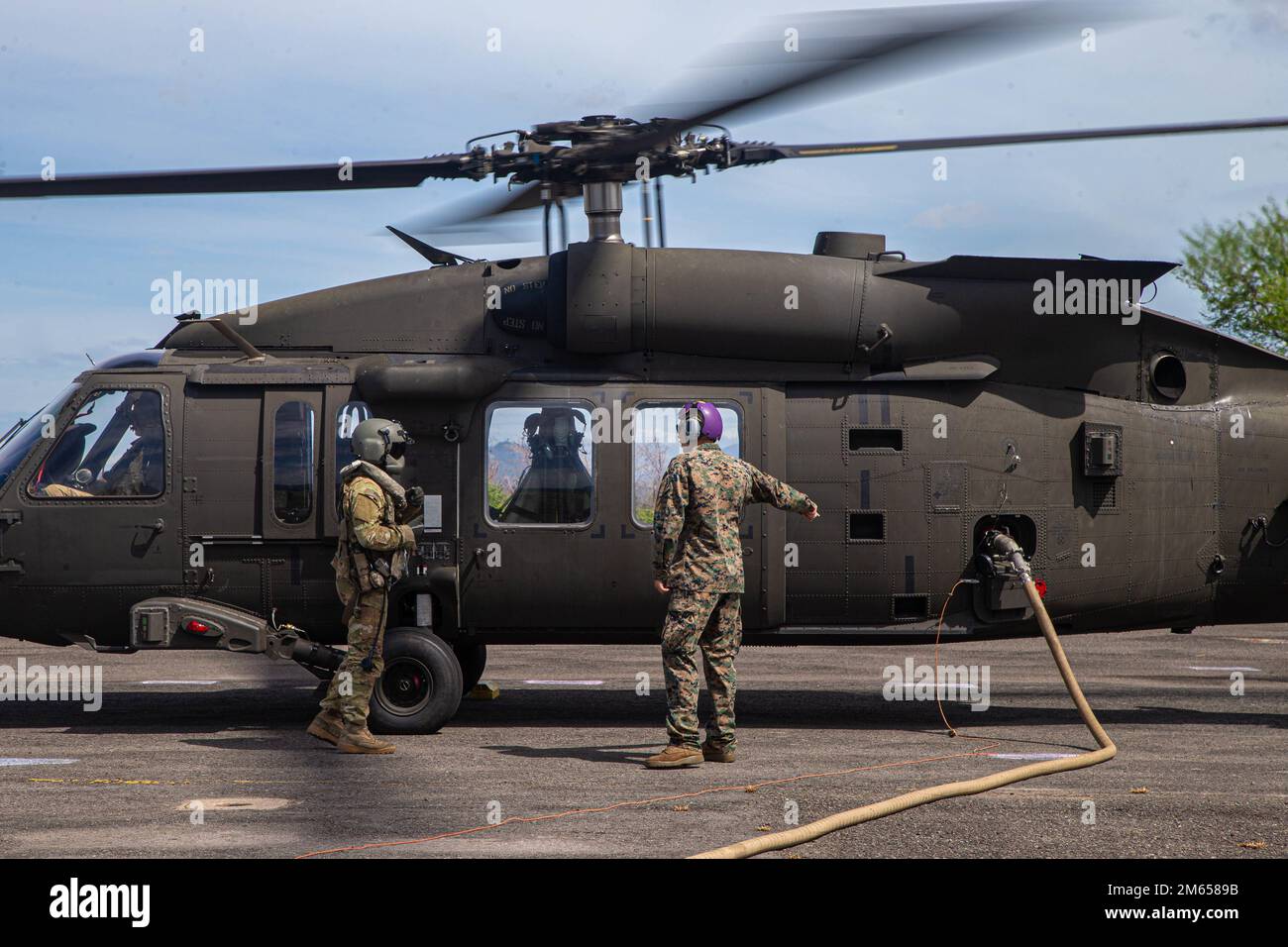 EIN US-AMERIKANISCHER Marinesoldat wurde dem Marinesoldat 172 (MWSS-172) zugeteilt, und ein Soldat mit der 25. Kampfluftfahrtbrigade, 25. Infanteriedivision, betankte einen Army UH-60 Hawk Helikopter an einem vorderen Scharfstellen- und Tankpunkt während Balikatan 22 in Subic Bay, Philippinen, 3. April 2022. Balikatan ist eine jährliche Übung zwischen den Streitkräften der Philippinen und dem US-Militär, die darauf abzielt, die bilaterale Interoperabilität, Fähigkeiten, Vertrauen und Zusammenarbeit zu stärken, die über Jahrzehnte hinweg aus gemeinsamen Erfahrungen aufgebaut wurden. Balikatan, Tagalog für „Schulter-zu-Schulter“, ist eine langjährige bilaterale Übung Stockfoto