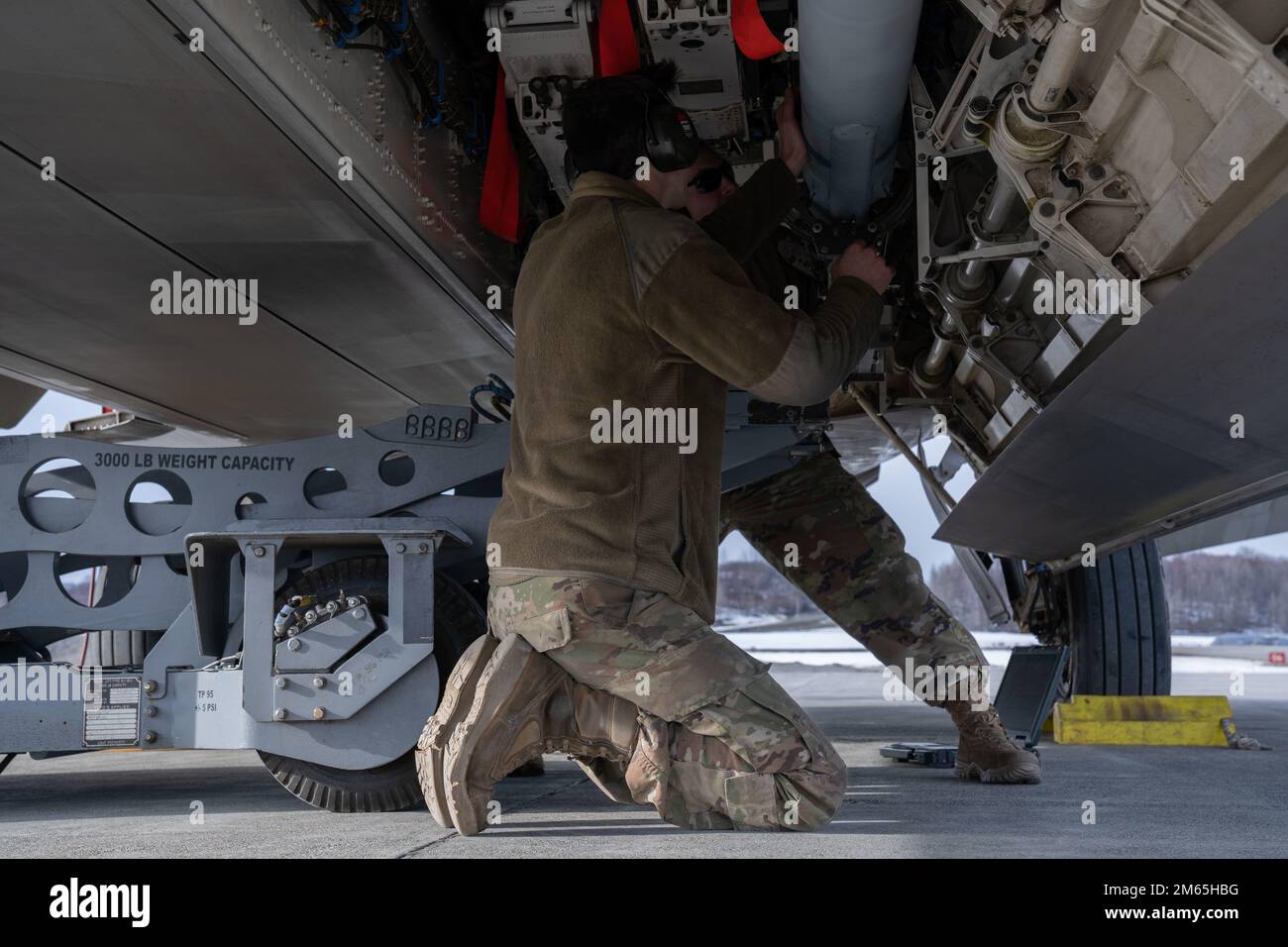 USA Air Force Airmen, die der 90. Kampfgeschwader zugeteilt sind, bereiten sich auf das Verladen einer Gefangenenrakete 120-C in die USA vor Air Force F-22 Raptor während der Übung Polar Force 22-4 auf der Joint Base Elmendorf-Richardson, 4. April 2022. Die F-22 erhöht die Letalität gegen alle hoch entwickelten Bedrohungen in der Luft, indem sie die feindlichen Fähigkeiten minimiert, den Jet zu verfolgen und mit ihm zu interagieren, aufgrund seiner Tarnfunktion, integrierten Avionik und Supercruise-Eigenschaften. Die Eigenschaften des F-22 bieten Synergieeffekte und erhöhen die Letalität gegen alle fortgeschrittenen Bedrohungen in der Luft. Stockfoto