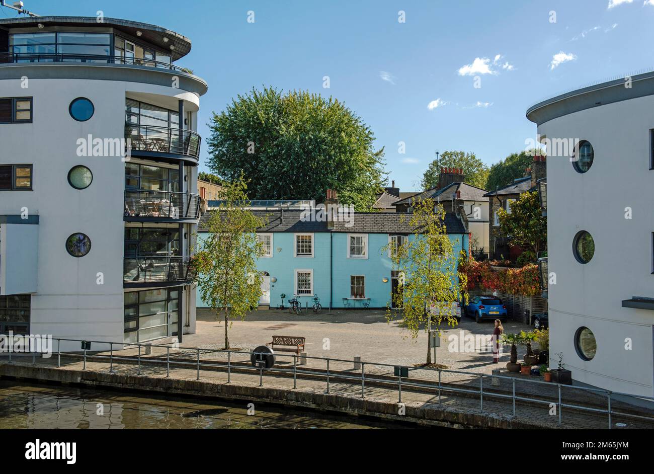 Blau bemalte Terrassenhäuser oder Hütten zwischen modernen Wohnungen, Lawfords oder Lawford's Wharf mit Blick auf Regent's Canal London Borough of Camden Stockfoto