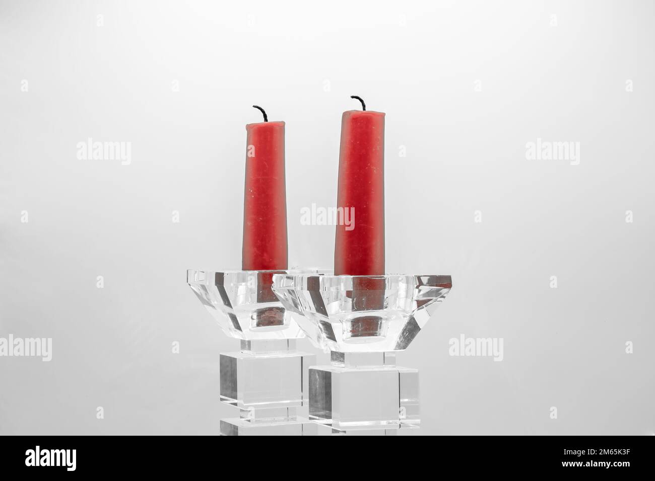 Zwei rote Kerzen in Kerzenhaltern aus klarem Glas Stockfoto