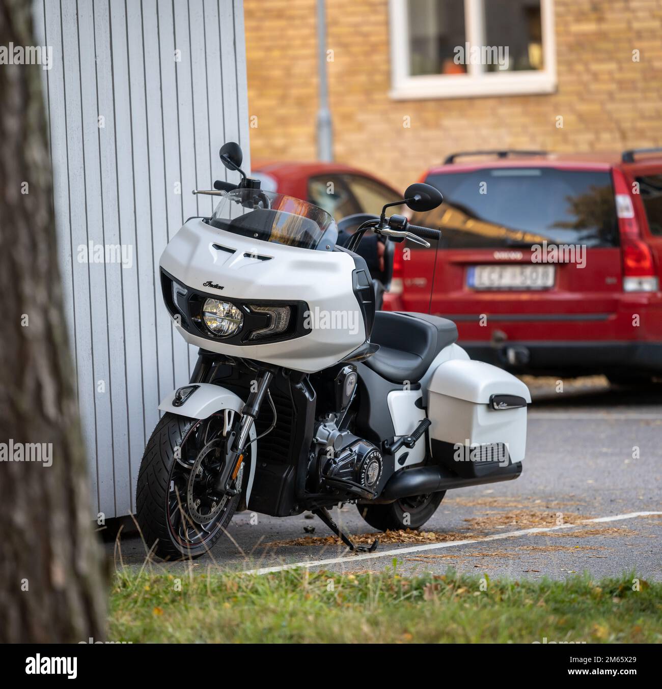 Göteborg, Schweden - Oktober 03 2022: Weißes, indisches Challenger-Motorrad an einem blauen Schuppen geparkt Stockfoto