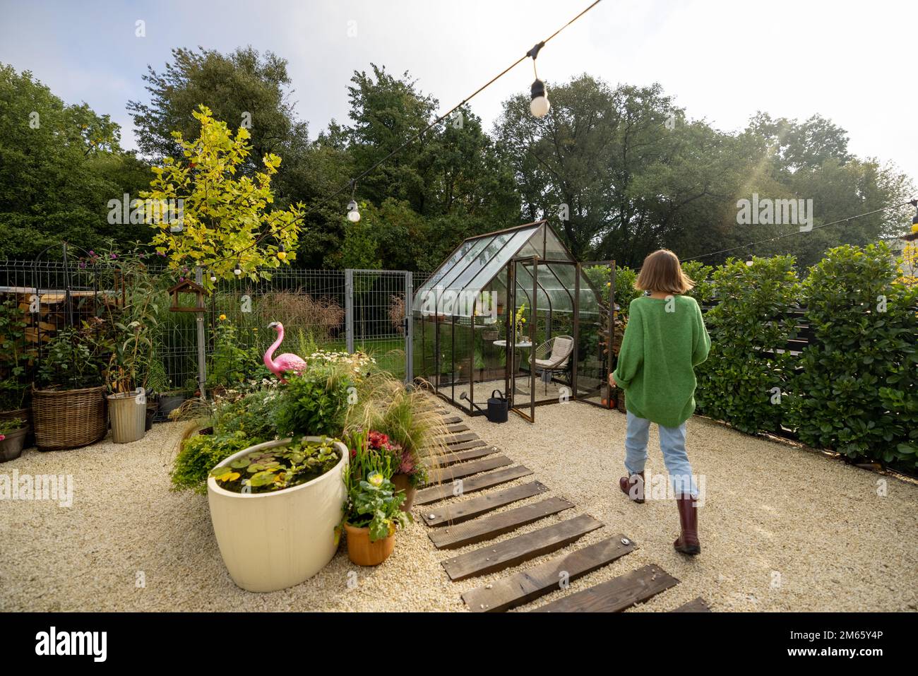 Eine Frau, die in einem schönen, winzigen Garten arbeitet Stockfoto
