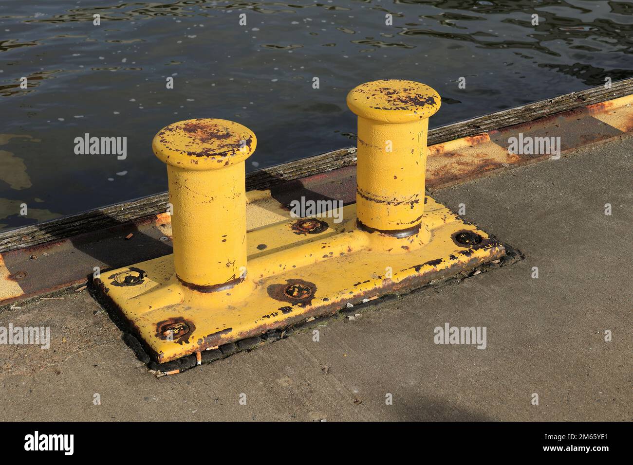 Gelber Pfosten zum Festmachen von Schiffen im Hamburger Hafen Stockfoto