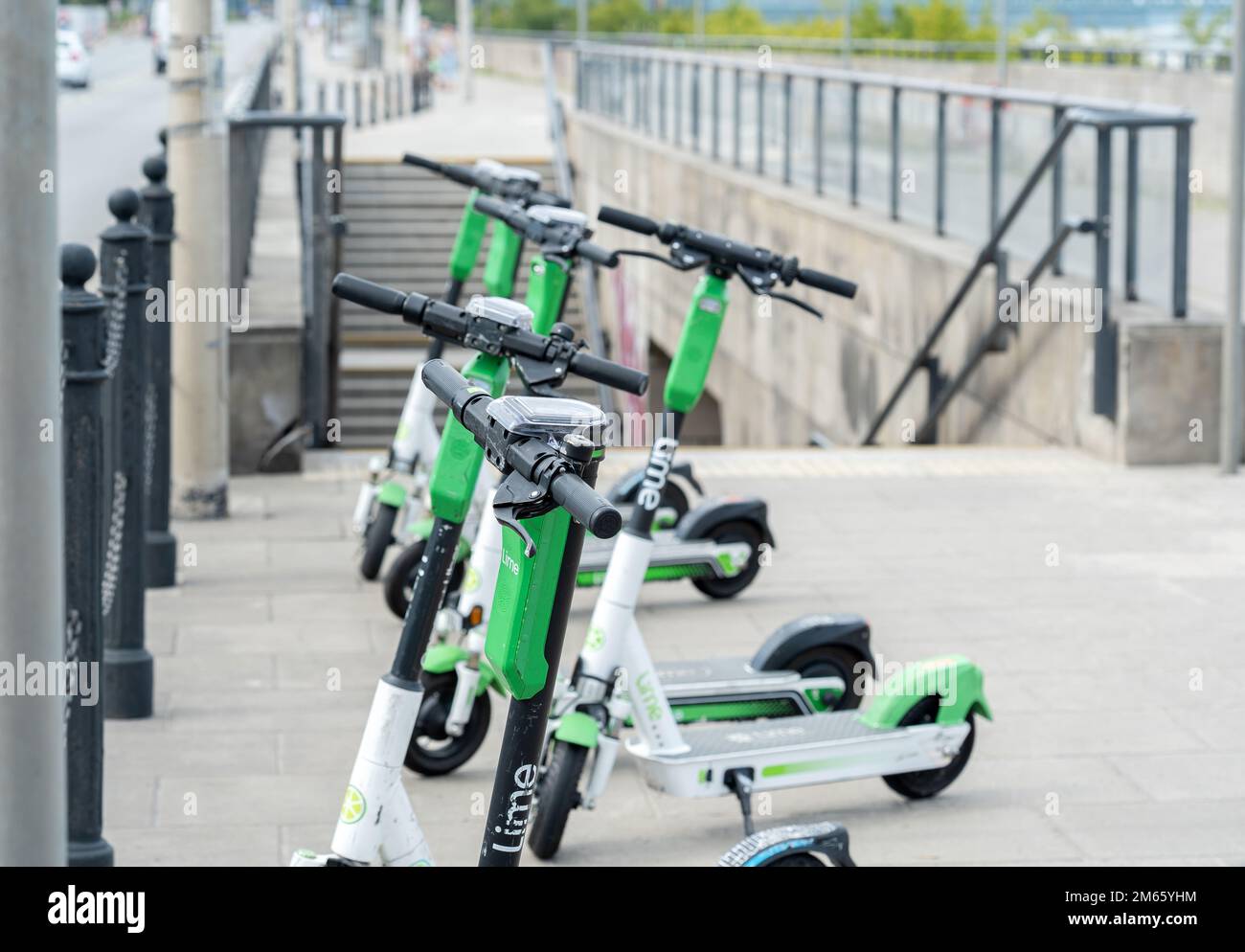 Eine Gruppe von Lime-Elektrorollern auf der Straße, effiziente umweltfreundliche Transportmittel für Fußgänger als Service. Pendelverkehr, Stadtleben, Stadtgebiet Stockfoto