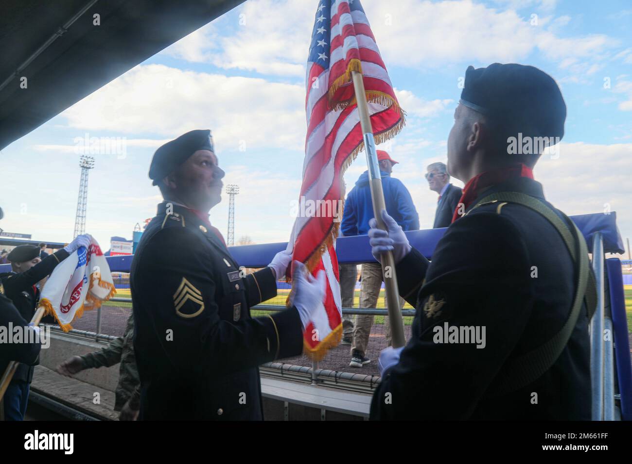 Staff Sgt. Jesse Larose und SPC. Jake Lee Harvey vom Hauptquartier und Hauptquartier Battery, 10. Mountain Division Artillery, 10. Mountain Division, öffnen Sie die amerikanische Flagge, bevor sie sich auf das Baseballfeld im NBT Bank Stadium in Syracuse, N.J., begeben, 5. April 2022. Die Syracuse Mets spielten an ihrem Eröffnungstag gegen die Scranton/Wilkes-Barre Railriders. Stockfoto