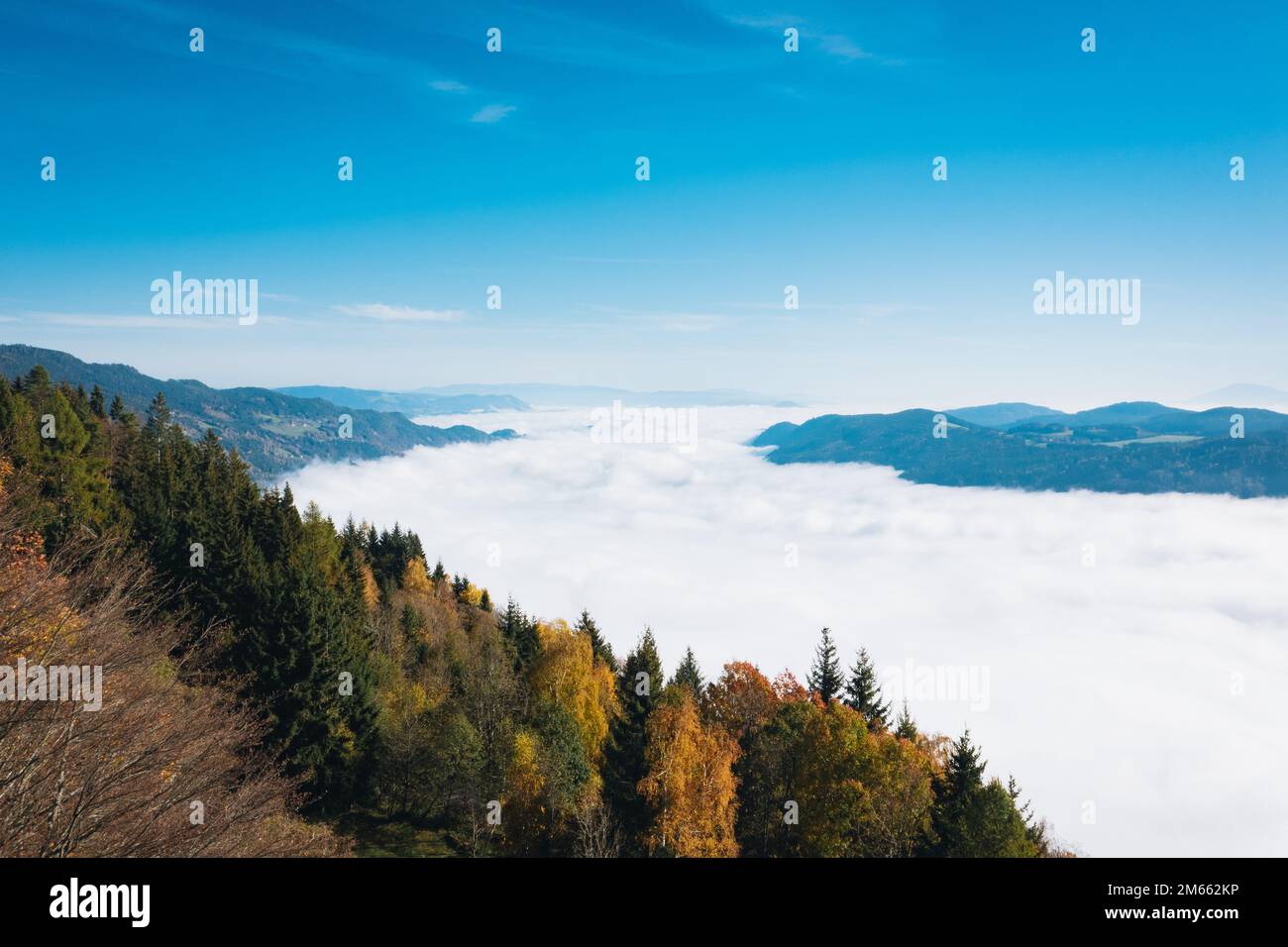 Blick auf Gerlitzen über den Wolken und den Ossiacher See. Malerisches Panorama am blauen Himmel an einem sonnigen Herbsttag. Stockfoto