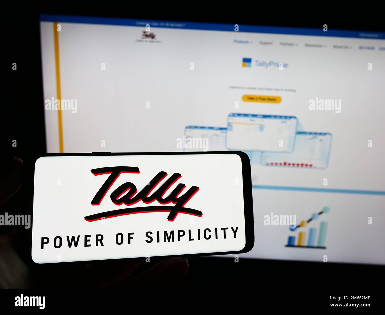 Person, die ein Mobiltelefon mit dem Logo des Softwareunternehmens Tally Solutions Pvt. Ltd. Auf dem Bildschirm vor der Webseite hält. Konzentrieren Sie sich auf das Display des Telefons. Stockfoto
