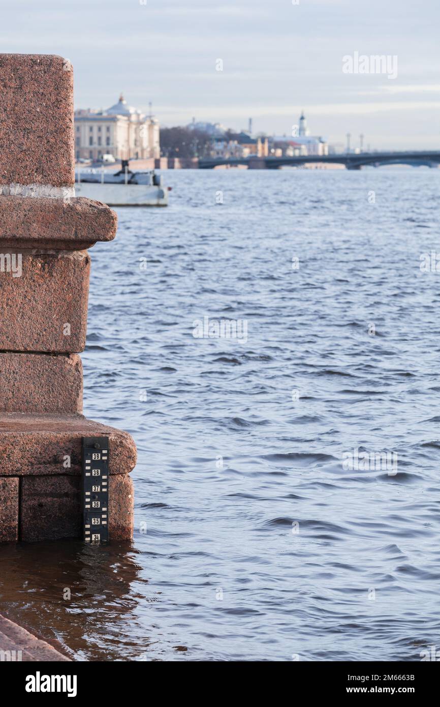 Gezeitenanzeige am Granitufer des Flusses Newa, Sankt Petersburg, Russland. Vertikales Foto Stockfoto