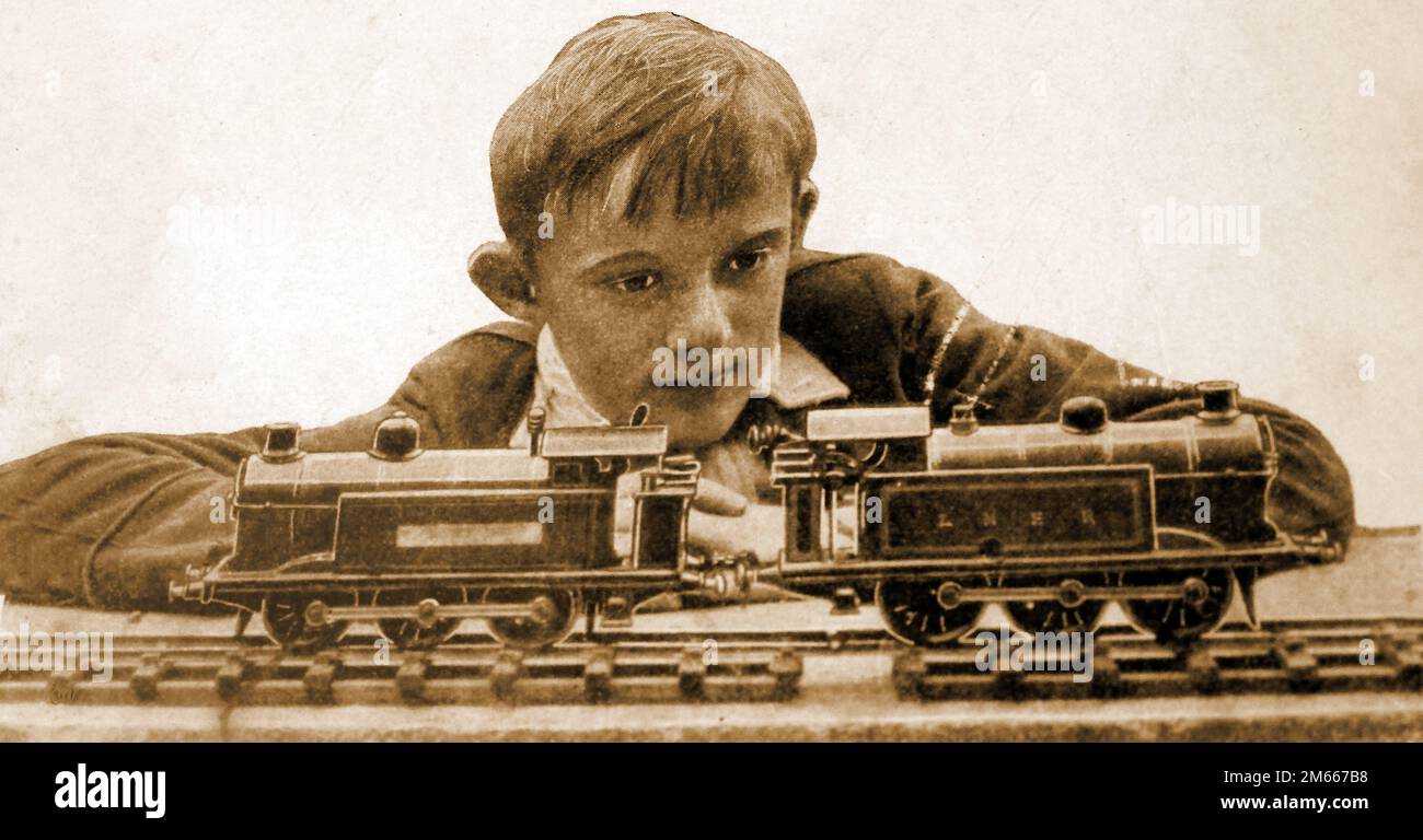 Ein 1930 erstelltes Bild eines Schuljungen mit seinem Modelleisenmotor, der linken mit Uhrwerk und der linken mit kleinen Dampfkapseln. Stockfoto