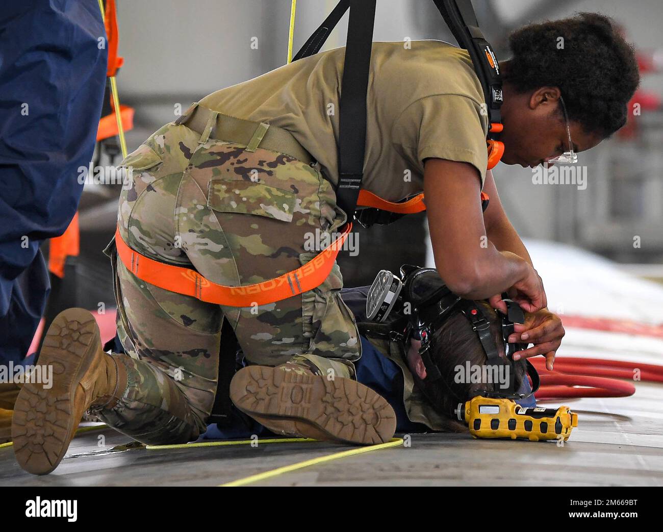 USA Air Force Airman 1. Class Jecol Roy, 86. Maintenance Squadron Fuel Maintenance Journeyman, entfernt eine Atemschutzmaske von einem Airman, der während einer jährlichen Übung zum Absaugen von Treibstofftanks am Luftwaffenstützpunkt Ramstein, Deutschland, am 6. April 2022 als nicht reagierender Betreffender fungiert. Roy erfüllte die Aufgaben eines Läufers während dieses simulierten Trainings, bei dem der Teilnehmer aufgrund des Einatmens von Dämpfen nicht mehr reagierte. Stockfoto