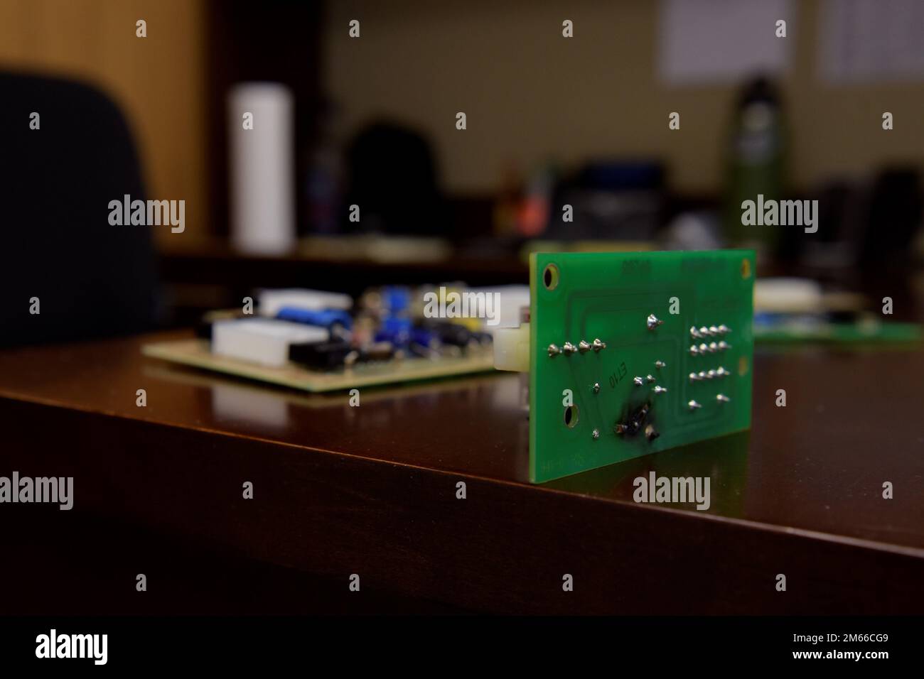 Eine Leiterplatte mit gebratener Bahn befindet sich am 6. April 2022 auf einem Schreibtisch im Luftwaffenstützpunkt Ramstein. USA Air Force Master Sgt. Kyle Shoup, 86. Wartungsgeschwader Air Force Repair Enhancement Program Manager, repariert Leiterplatten mit Teilen von anderen Leiterplatten, die nicht repariert werden können. Stockfoto
