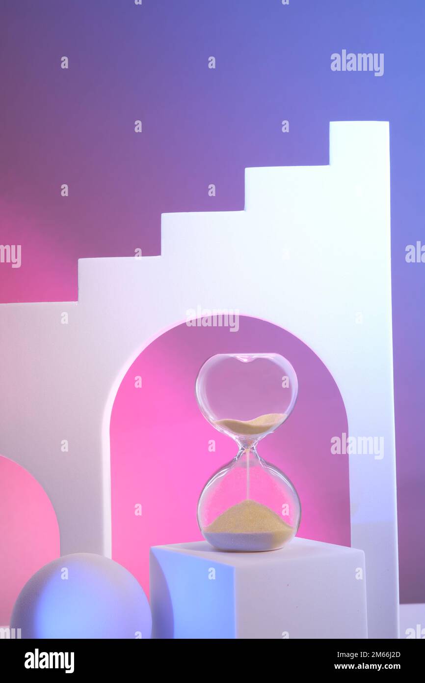 Sanduhr auf dem Podium. Surreale Bögen in pinkfarbenem und violettem Neonlicht. Hour Glass ist auch als Sandglas, Sanduhr oder Sanduhr bekannt. Stockfoto