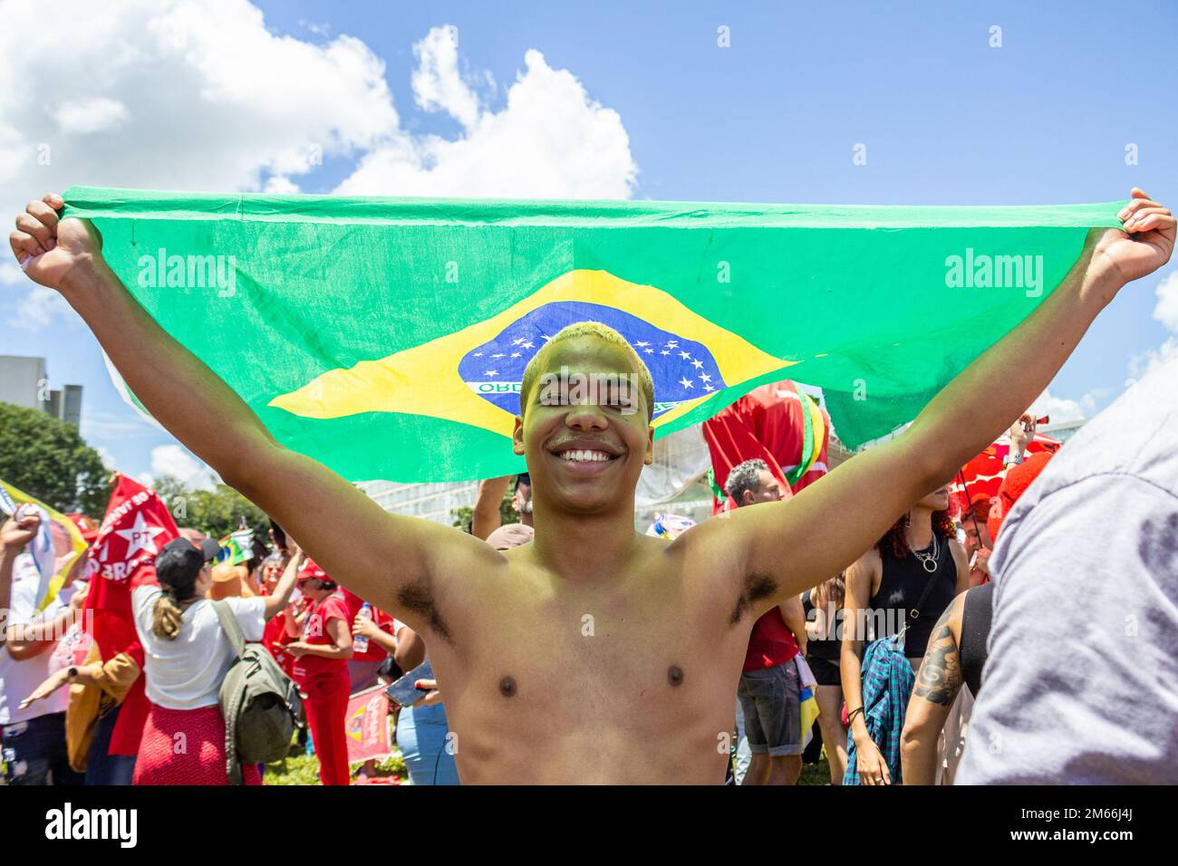 Brasília, DF, Brasilien – 01. Januar 2023: Ein Junge, der sich mit einer brasilianischen Flagge vor der starken Sonne schützt. Amtseinführung von Präsident Lula. Stockfoto