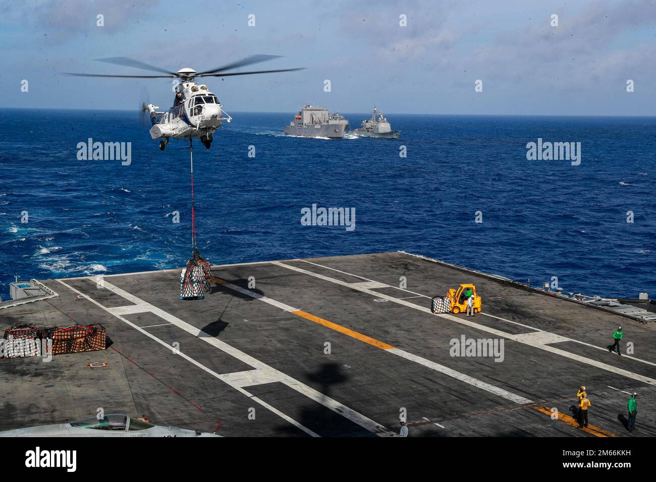 PHILIPPINE SEA (7. April 2022) ein AS332 Super Puma transportiert Fracht auf den Flugzeugträger der Nimitz-Klasse USS Abraham Lincoln (CVN 72) während einer Wiederauffüllung auf See mit dem Trockenfracht- und Munitionsschiff des Militärsealift-Kommandos USNS Richard E. Byrd (T-AKE 4) zusammen mit dem geführten Raketenschiff USS Mobile Bay der Ticonderoga-Klasse (CG 53). Die Abraham Lincoln Strike Group befindet sich in einem geplanten Einsatz im US-7.-Flottenbereich, um die Interoperabilität durch Allianzen und Partnerschaften zu verbessern und gleichzeitig als einsatzbereite Truppe zur Unterstützung einer freien und offenen Region Indo-Pacific zu fungieren. Stockfoto