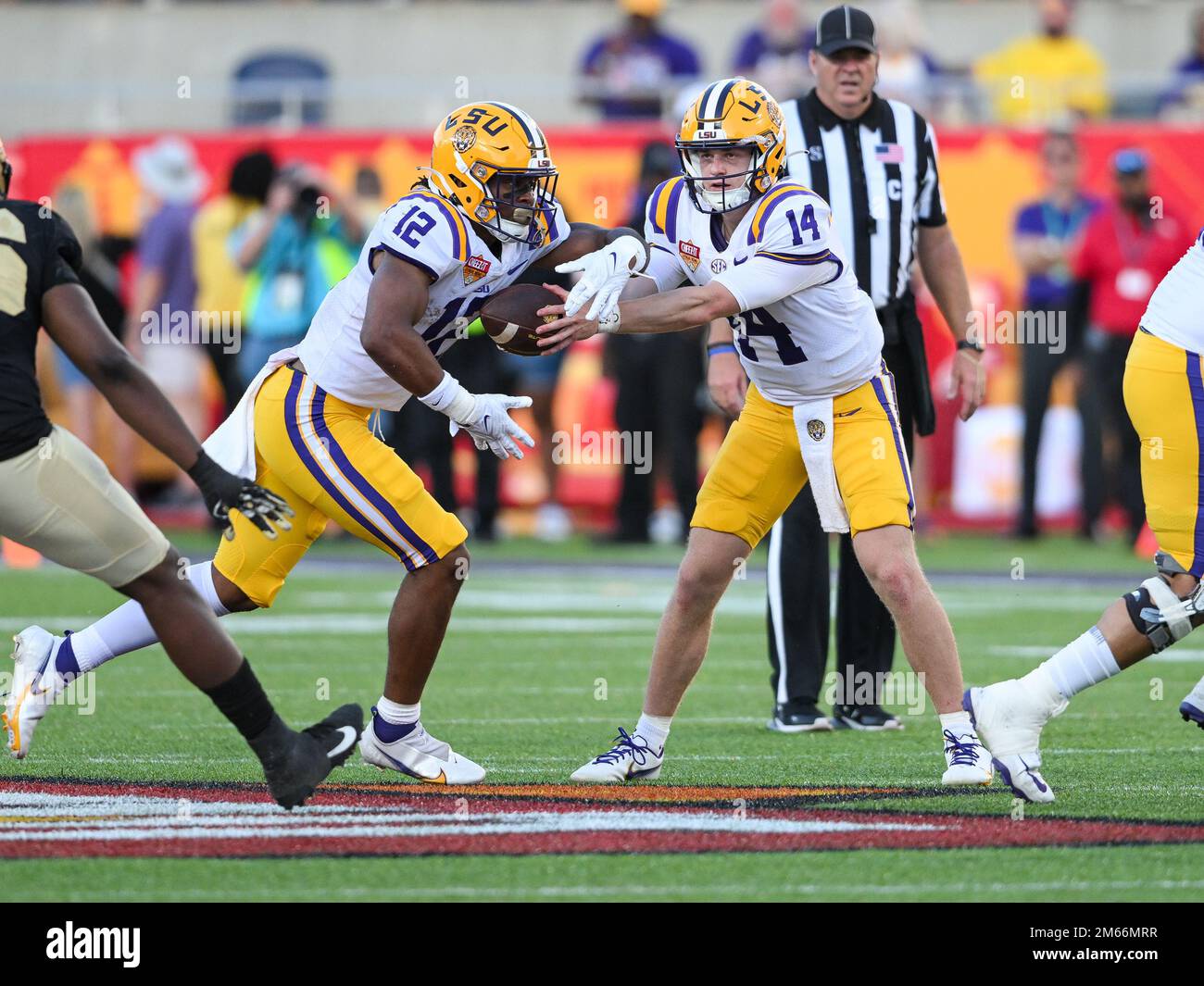 Orlando, Florida, USA. 2. Januar 2023: LSU Tigers Quarterback Walker Howard (14) übergibt den Ball während der 2. Hälfte des Cheez-IT Citrus Bowl zwischen LSU Tigers und Purdue Boilermakers an LSU Tigers Safety Derrick Davis Jr. (12). LSU besiegte Purdue 63-7 im Camping World Stadium in Orlando, FL. Romeo T Guzman/CSM Kredit: CAL Sport Media/Alamy Live News Stockfoto