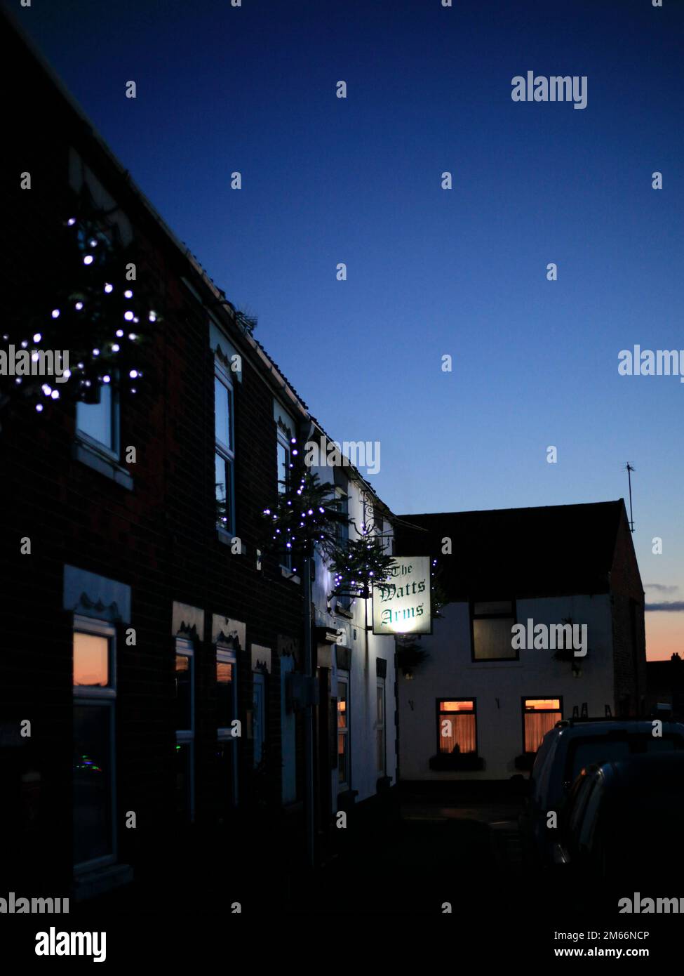 Festliche Weihnachtslichter im ländlichen Dorf Ottringham Holderness East Riding of Yorkshire England UK bei Sonnenuntergang mit tiefblauem Himmel Stockfoto