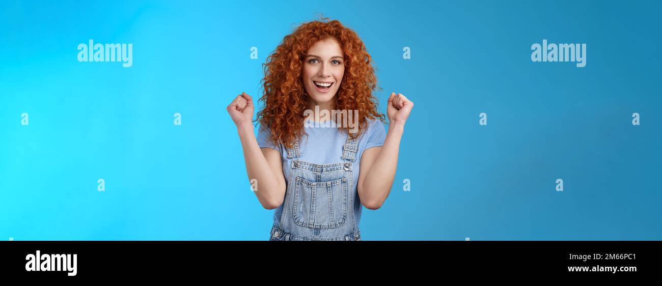 Hurra erfolgreicher Tag. Fröhlich chrismastic Rotschopf Mädchen Sommer Latzhose klatschen Fäuste fröhlich lächelnd breit entschlossen Erfolg zu erreichen, triumphierend Stockfoto