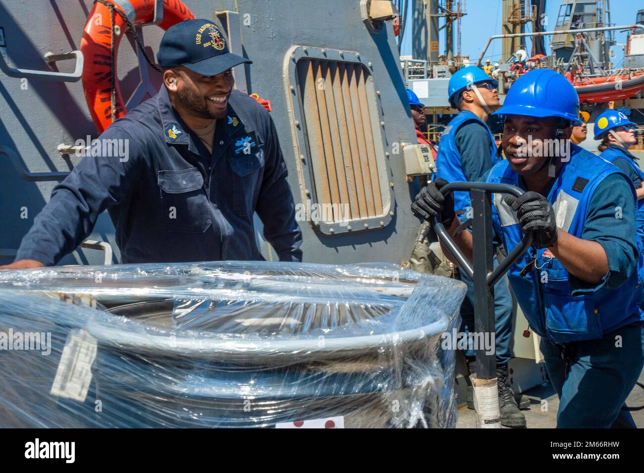 220408-N-UP745-1338 Ost-Mittelmeer (8. April 2022) Seeleute an Bord des Arleigh-Burke-Klasse-Guided-Missile Destroyer USS Jason Dunham (DDG 109) verwenden einen Palettenhubwagen, um Paletten zu transportieren, die sie von Henry J. Kaiser-Class Replenishment Oiler USNS Laramie (T-AO-203) während eines Replenishment-at-Sea-Replenishment am 8. April 2022 erhalten haben. Jason Dunham ist Teil der Harry S. Truman Carrier Strike Group, deren Einsatz im US-Flottenbereich 6. geplant ist, um die Interessen der USA, Verbündeten und Partner in Europa und Afrika zu unterstützen. Stockfoto