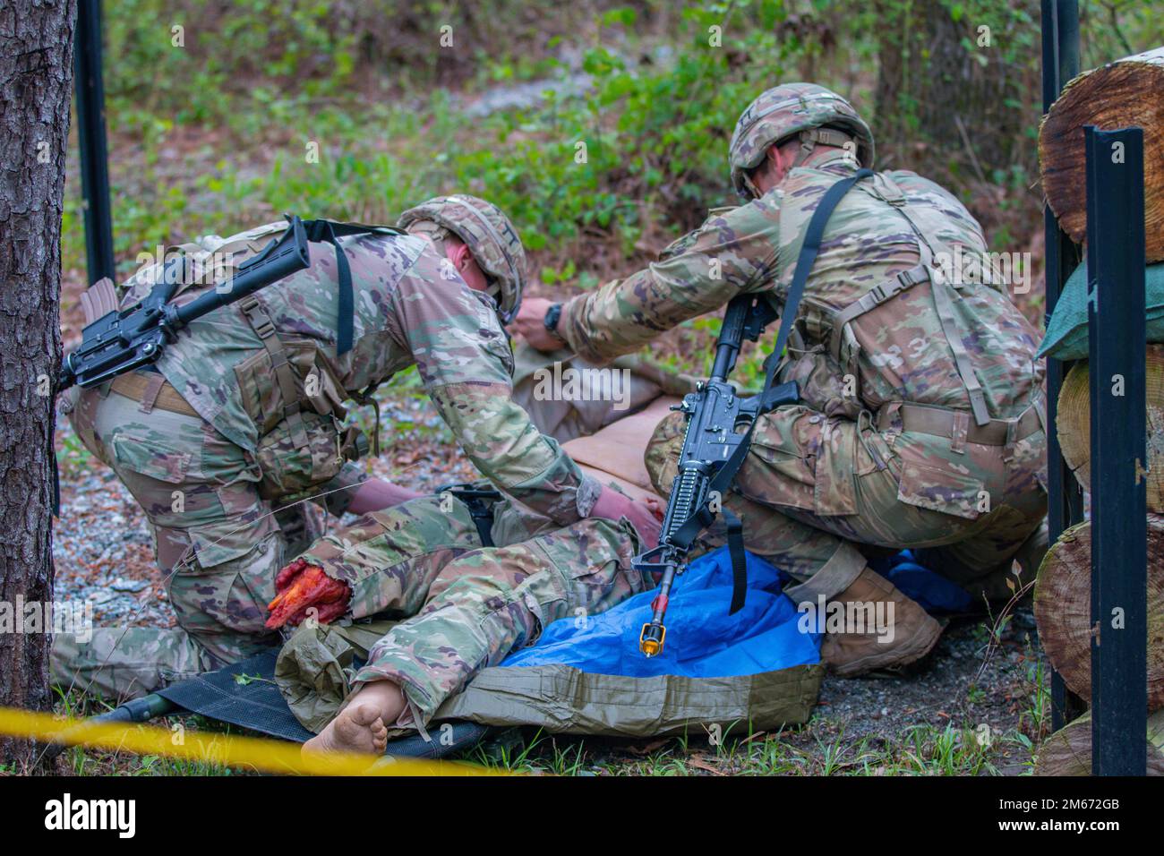 1. LT. Michael Singer und 1. LT. Matt McKenzie von der 101. Airborne Division (Luftangriff) helfen bei der alljährlichen Auslosung der besten Ranger in Fort Benning, GA, am 9. April 2022 bei Verletzungen an einer Prüfpuppe. Der Zweck dieser Spur war es, medizinische Fähigkeiten zu testen, während man in einer feindlichen Umgebung Feuer bekam. Stockfoto