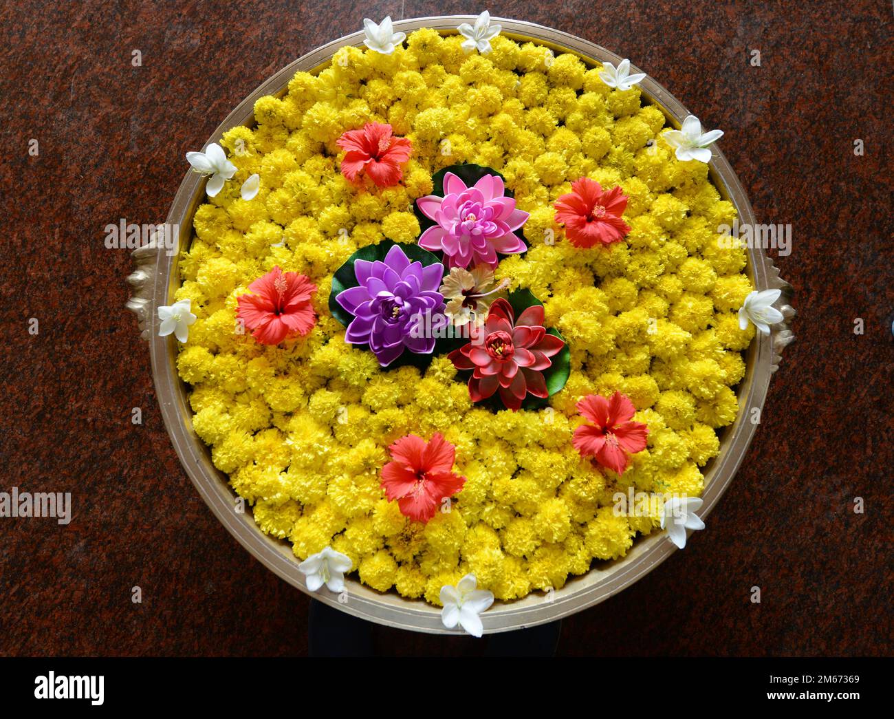Blumen in einer Schüssel mit Wasser - traditionelle Dekoration für Heiterkeit in Südindien. Stockfoto