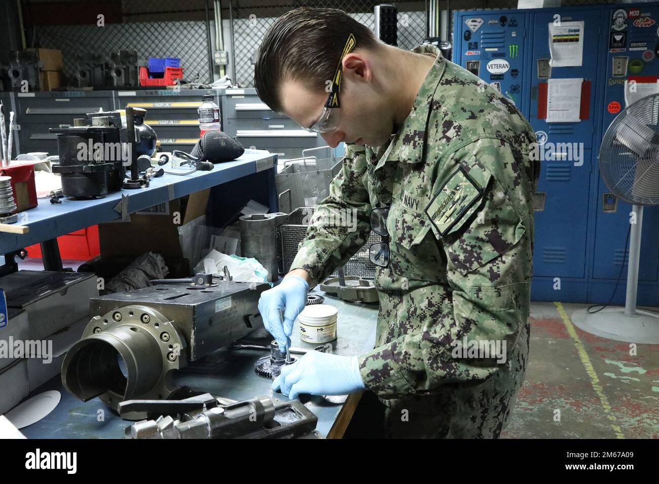 NORFOLK, VA (11. April 2022) Gunner's Mate 3. Class Anthony Pecoraio aus Philadelphia, Pennsylvania, trägt Schmiermittel auf eine Getriebebaugruppe auf, während sie in der Gun Shop des regionalen Wartungszentrums für den Mittelatlantik arbeitet. Stockfoto