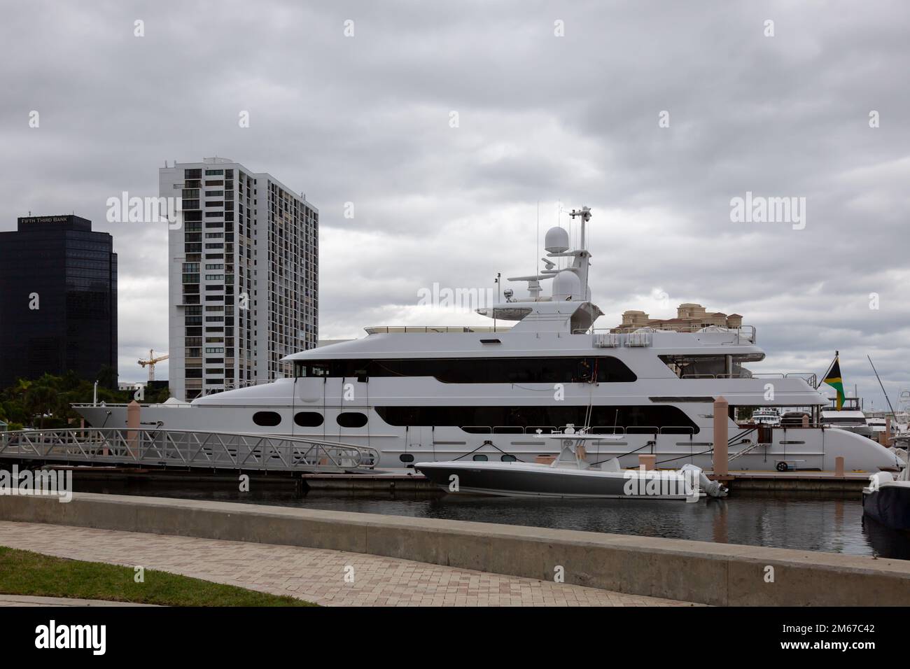 Eine Christensen Motoryacht, die an der Palm Harbor Marina in West Palm Beach, Florida, USA, mit Waterview Towers und Fifth Third Bank im Hintergrund verankert ist. Stockfoto Eine Christensen Motoryacht, die an der Palm Harbor Marina in West Palm Beach, Florida, USA, mit Waterview Towers und Fifth Third Bank im Hintergrund verankert ist. Stockfoto