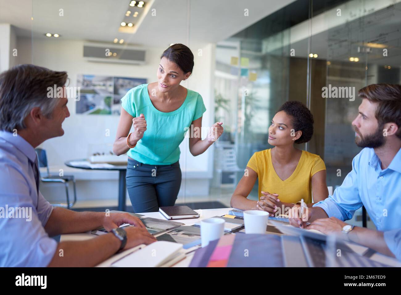 Sie bekam ihre volle Aufmerksamkeit. Eine attraktive junge Geschäftsfrau, die dem Team ihren Vorschlag erklärt. Stockfoto