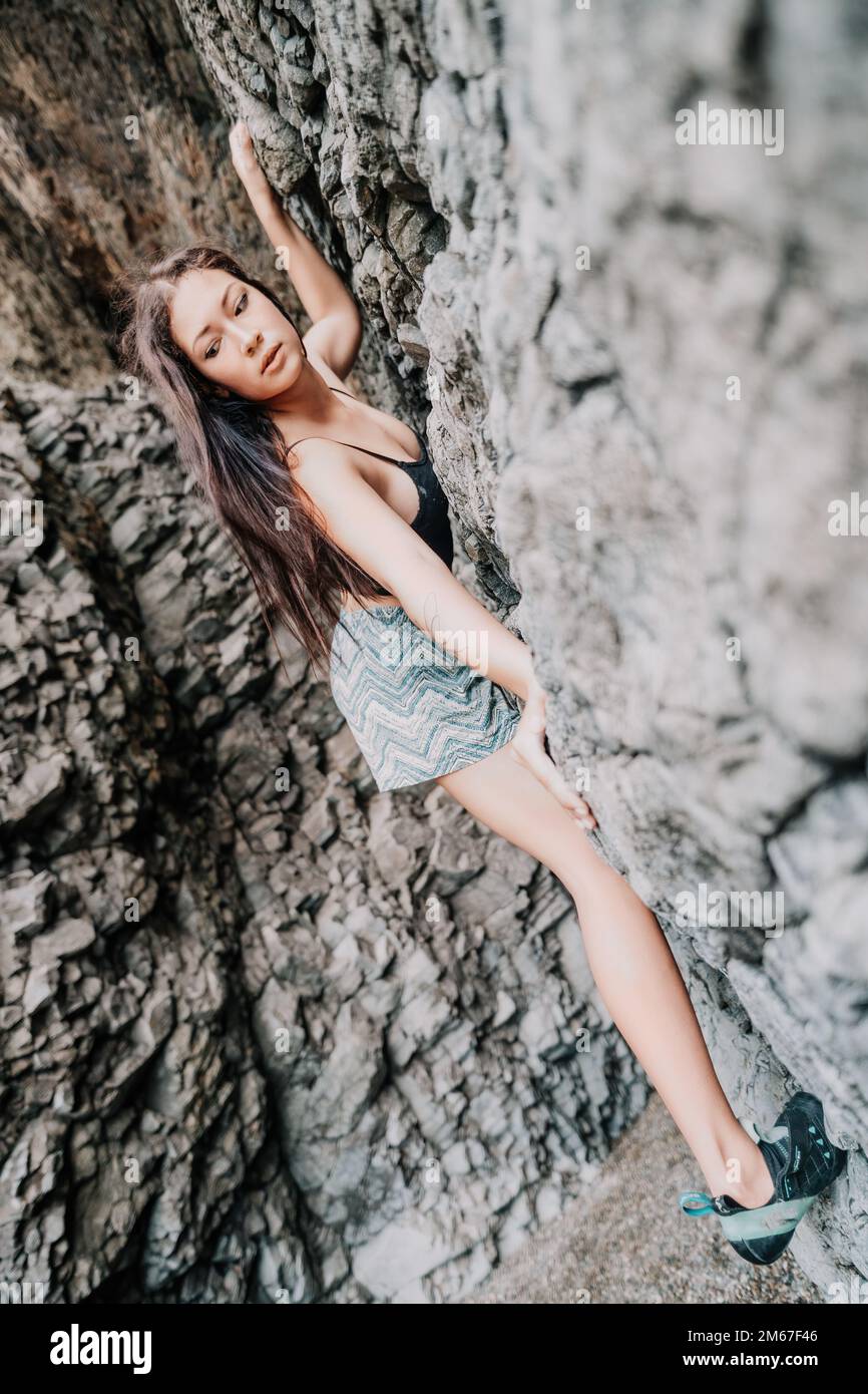 Sportlerin Klettert Auf Den Felsen. Junge Frau mit schlanker Passform Körper c Stockfoto