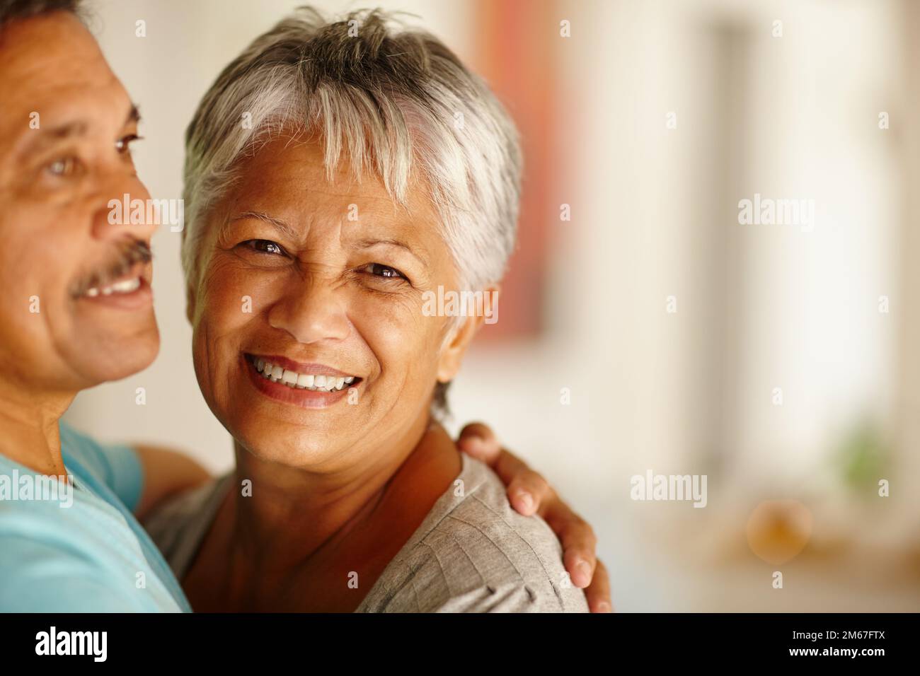 Er bringt mich zum Lachen. Porträt eines erwachsenen Ehepaars, das zu Hause umarmt. Stockfoto