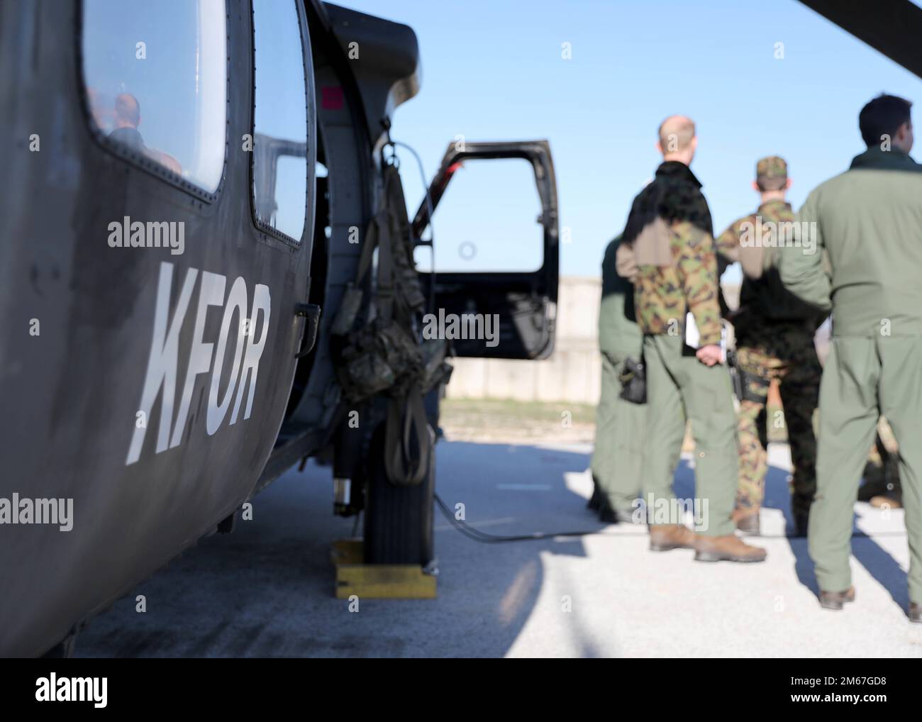 CAMP BONDSTEEL, Kosovo – Flugbesatzungen aus den USA, Kroatien und der Schweiz diskutieren ihren anstehenden Flug vor einem US-amerikanischen UH-60 Black Hawk Helikopter in Camp Bondsteel, Kosovo, 12. April 2022. Die drei Luftverkehrsteams, die Hubschrauber aus jedem der drei Länder anflogen, nahmen an dem Mehrschiffsflug über das Regionalkommando Ost der Kosovo-Streitkräfte Teil, um die Fähigkeiten und die Interoperabilität bei der Arbeit in einem multinationalen Umfeld zu verbessern. Stockfoto