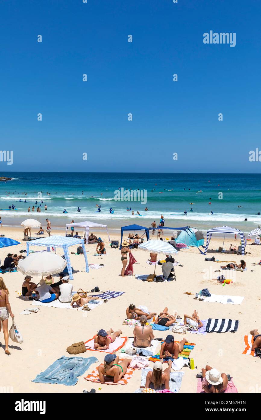 Leute sonnen sich auf Handtüchern Sommer am Bondi Beach Sydney, klarer blauer Himmel Januar 2023, einladend blauer Ozean, Sydney, Australien Stockfoto