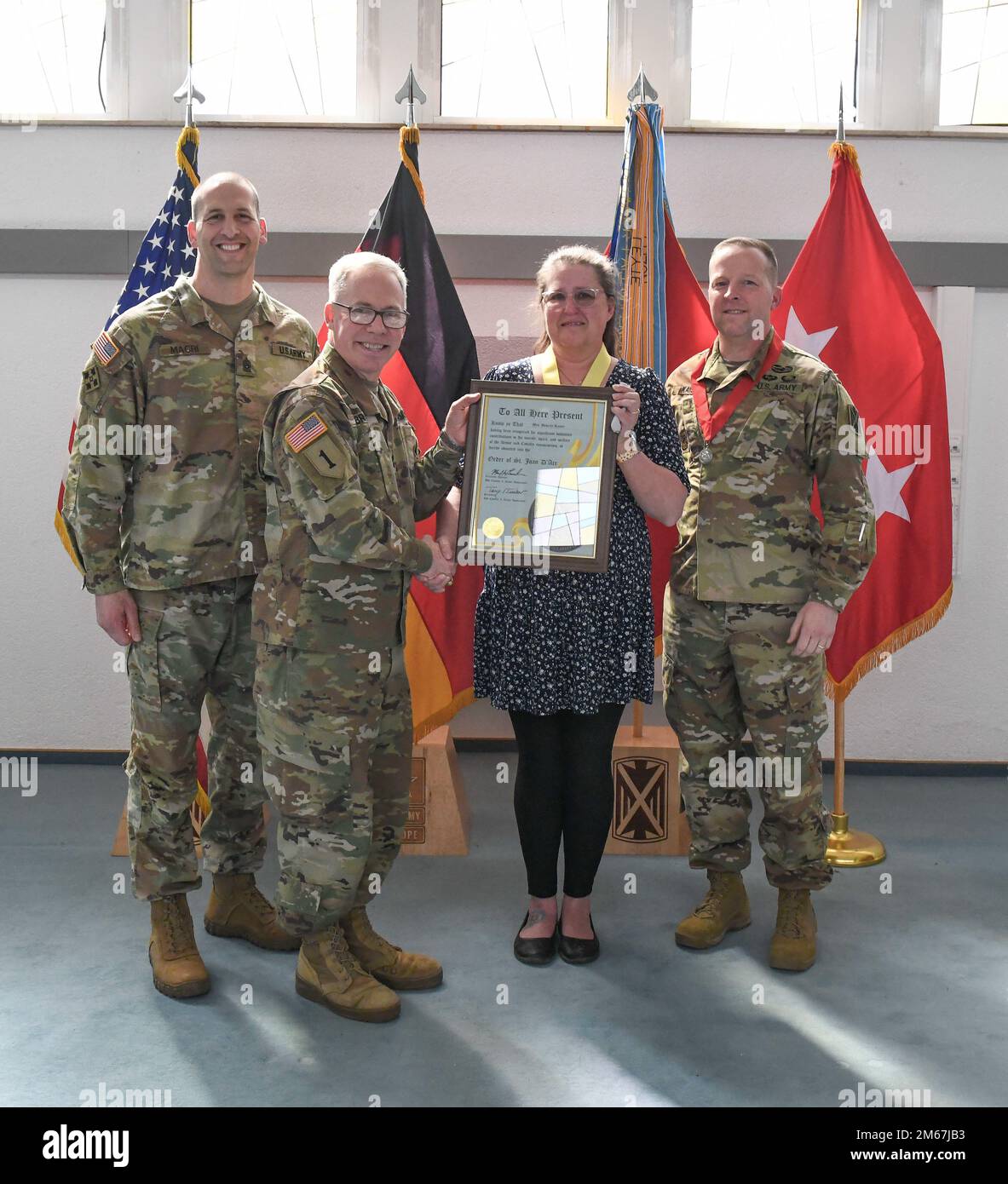 USA Generalmajor Gregory Brady und Kommandosgt. Major Giancarlo Macri, 10. Army Air and Missile Defense Command überreichen Frau Beverly Kaiser bei einer Preisverleihung zum Tag der heiligen Barbara am 12. April 2022 in der Sembach Chapel, Deutschland, den Saint Joan D'Arc Award. Mrs. Kaiser wurde mit diesem Armor Award für ihre außergewöhnlichen Beiträge für die Streitkräfte und die Luftwaffe über 20 Jahre ausgezeichnet. Stockfoto