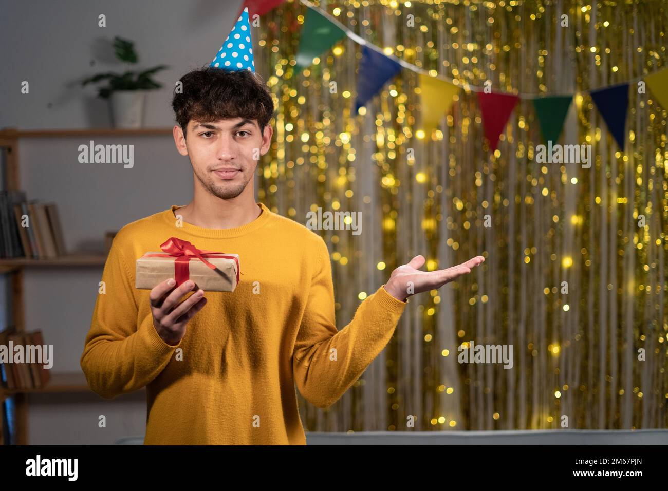 Portrait des positiven Guys Promoter Hand halten Show Werbung Werbegeschenk Verkauf Rabatt halten Geschenk Geburtstagsparty zu Hause machen Stockfoto