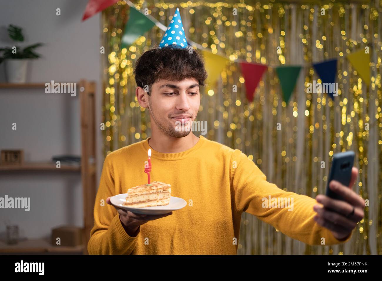 Ein arabischer Geburtstagskind-Blogger, der ein Video mit Kuchen aufnimmt, Geburtstagsselfie zu Hause Stockfoto