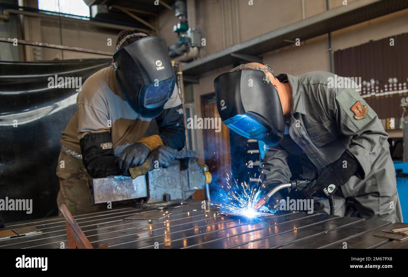 USA Air Force Tech Sgt. Aaron Barnes, 86. Wartungsgeschwader Flugzeugtechnologie, nicht kommissionierter Offizier, der verantwortlich ist, beobachtet Brigg. Gen. Josh Olson, 86. Airlift Wing Commander, Schweißübungen während eines Besuchs der 86. Maintenance Squadron Metallic Technology Sektion am Luftwaffenstützpunkt Ramstein, Deutschland, 13. April 2022. Im MTECH-Abschnitt werden verschiedene Schweißtechniken zur Reparatur verschiedener Teile und Geräte für die Basis verwendet. Stockfoto