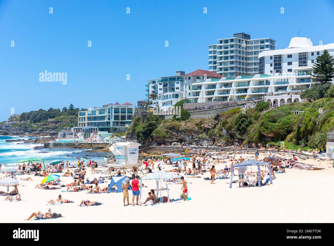 Bondi Beach in Sydney, Sommertag 2023, überfüllter Strand und Menschen im Meer, blauer Himmel, Sydney östliche Vororte, NSW, Australien Stockfoto