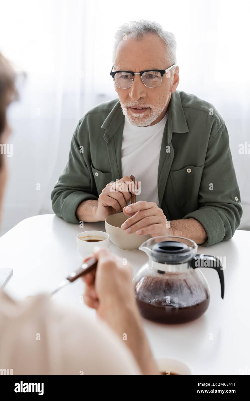 Ein aufmerksamer Mann mit Brille, der einen verschwommenen Sohn in der ...