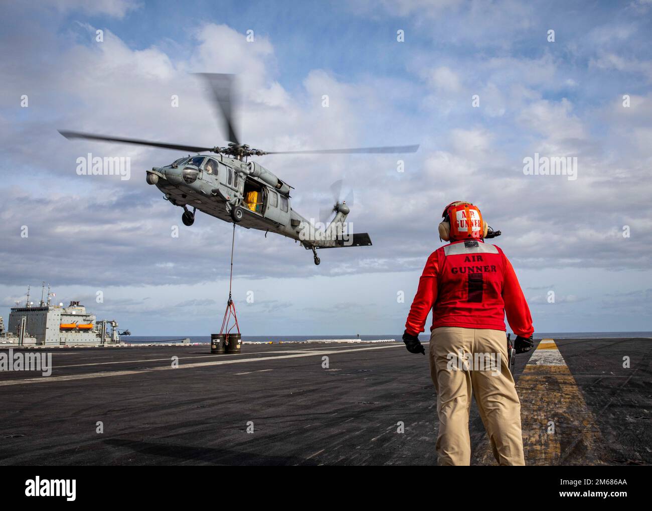 220416-N-SY758-1128 ATLANTISCHER OZEAN (16. April 2022) ein MH-60s Sea Hawk Hubschrauber, der am Helicopter Sea Combat Squadron (HSC) 7 befestigt ist, deponiert Munition auf dem Cockpit des Flugzeugträgers USS George H.W. Bush (CVN 77) während einer Munitionsladung mit der Trockenladung USNS William McLean (T-AKE 12), 16. April 2022. George H.W. Bush bietet der nationalen Kommandobehörde flexible, anpassbare Kampfkapazitäten durch die Trägerstreikgruppe, die die maritime Stabilität und Sicherheit aufrechterhält, um den Zugang zu gewährleisten, Aggressionen abzuwehren und die Interessen der USA, Verbündeten und Partner zu verteidigen. Stockfoto