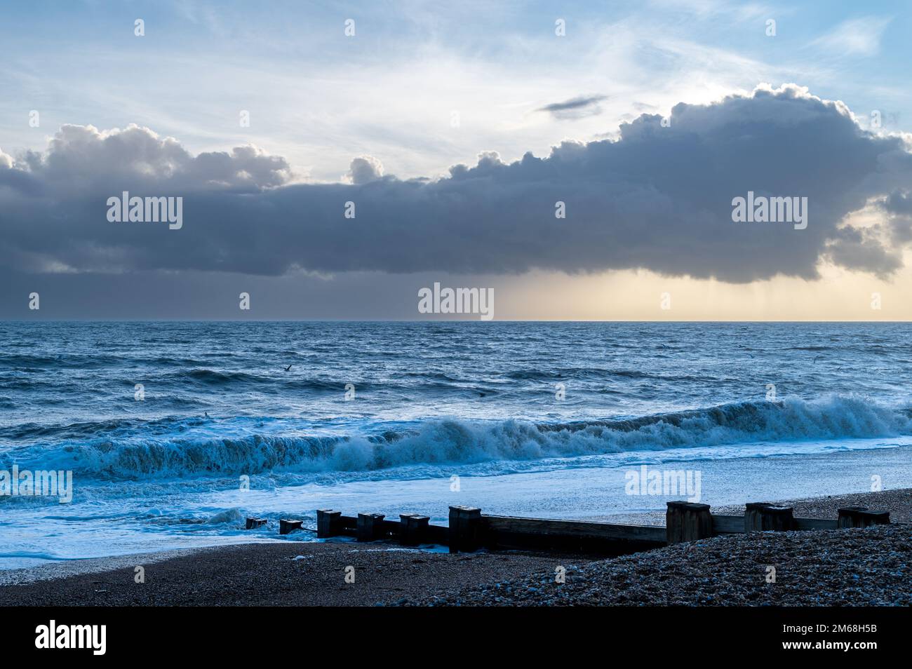 Dramatische Wolken über dem Meer und am Strand in Bexhill-on-Sea, Großbritannien Stockfoto