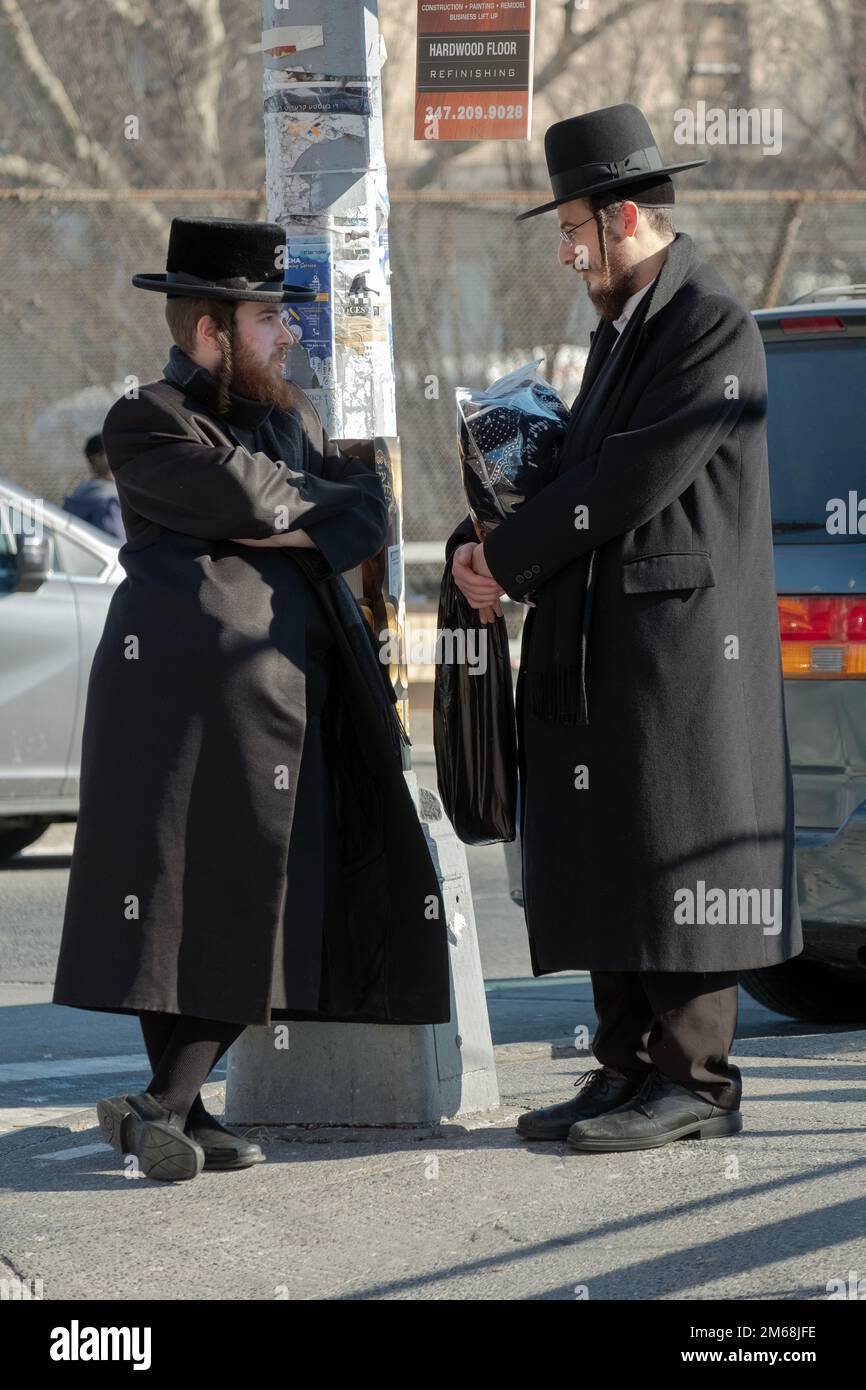 Zwei chassidische Männer treffen sich nach dem Gottesdienst und halten für ein Gespräch. In Williamsburg, Brooklyn, New York City. Stockfoto