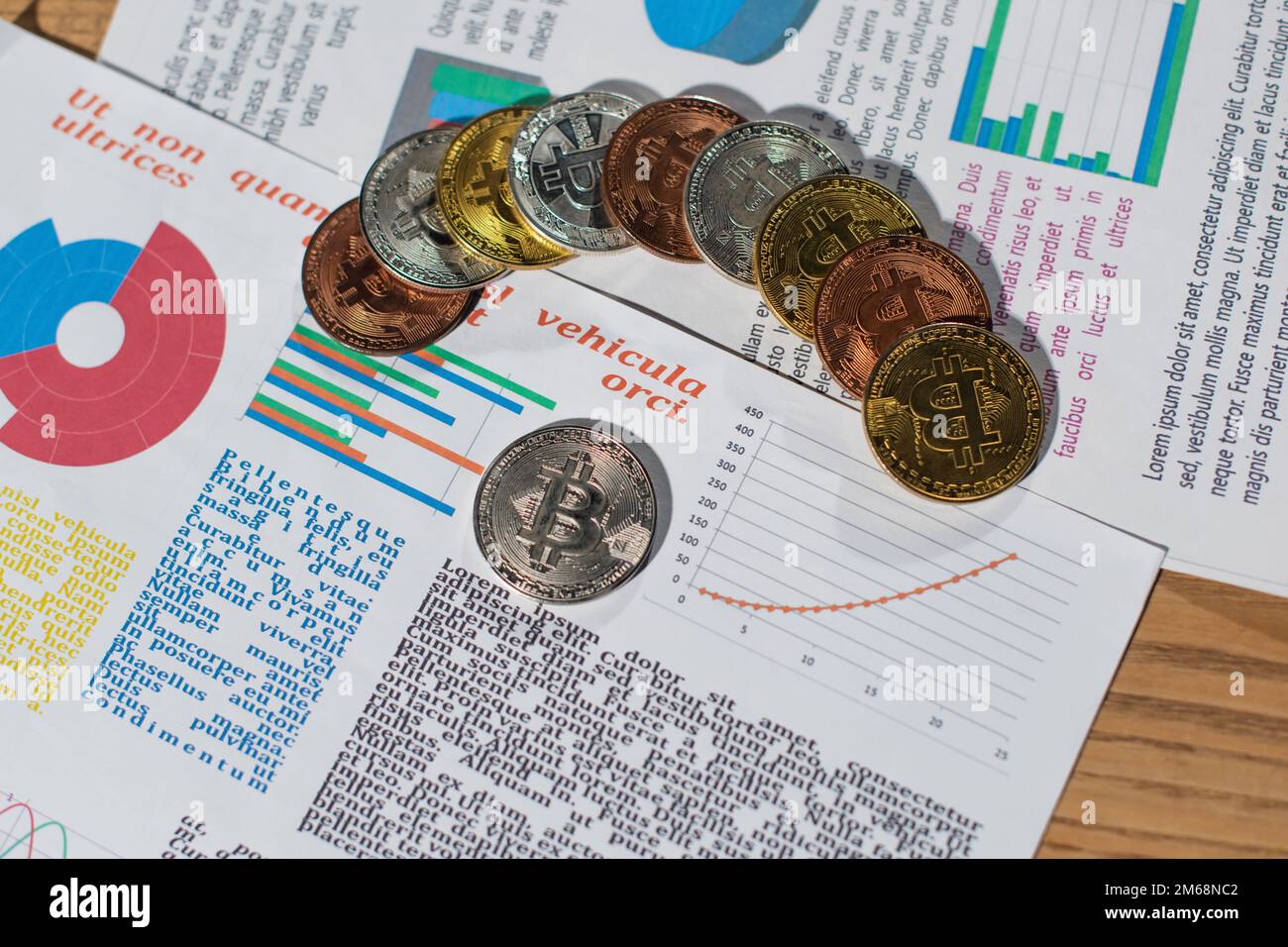 KIEW, UKRAINE - 17. NOVEMBER 2022: Draufsicht auf silberne und goldene Bitcoins auf Papieren mit Text und Infografiken Stockfoto