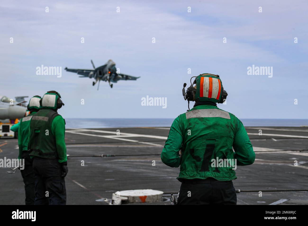 PHILIPPINISCHE SEE (19. April 2022) Seeleute beobachten den Flugbetrieb auf dem Cockpit des Flugzeugträgers der Nimitz-Klasse USS Abraham Lincoln (CVN 72). Die Abraham Lincoln Strike Group befindet sich in einem geplanten Einsatz im US-7.-Flottenbereich, um die Interoperabilität durch Allianzen und Partnerschaften zu verbessern und gleichzeitig als einsatzbereite Truppe zur Unterstützung einer freien und offenen Region Indo-Pacific zu fungieren. Stockfoto