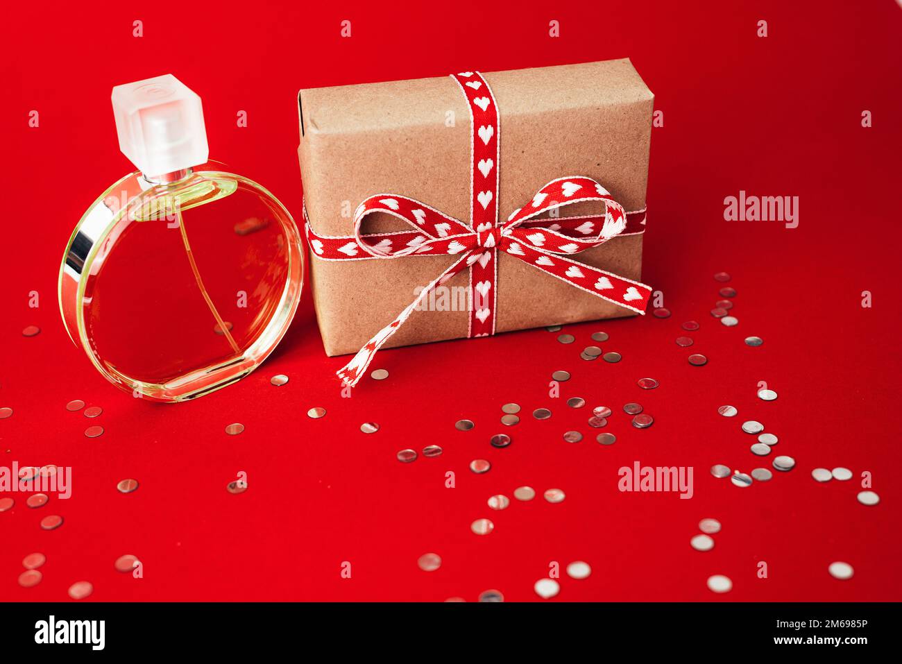 Parfüm und Geschenkbox auf rotem Hintergrund. Geschenk am valentinstag Stockfoto