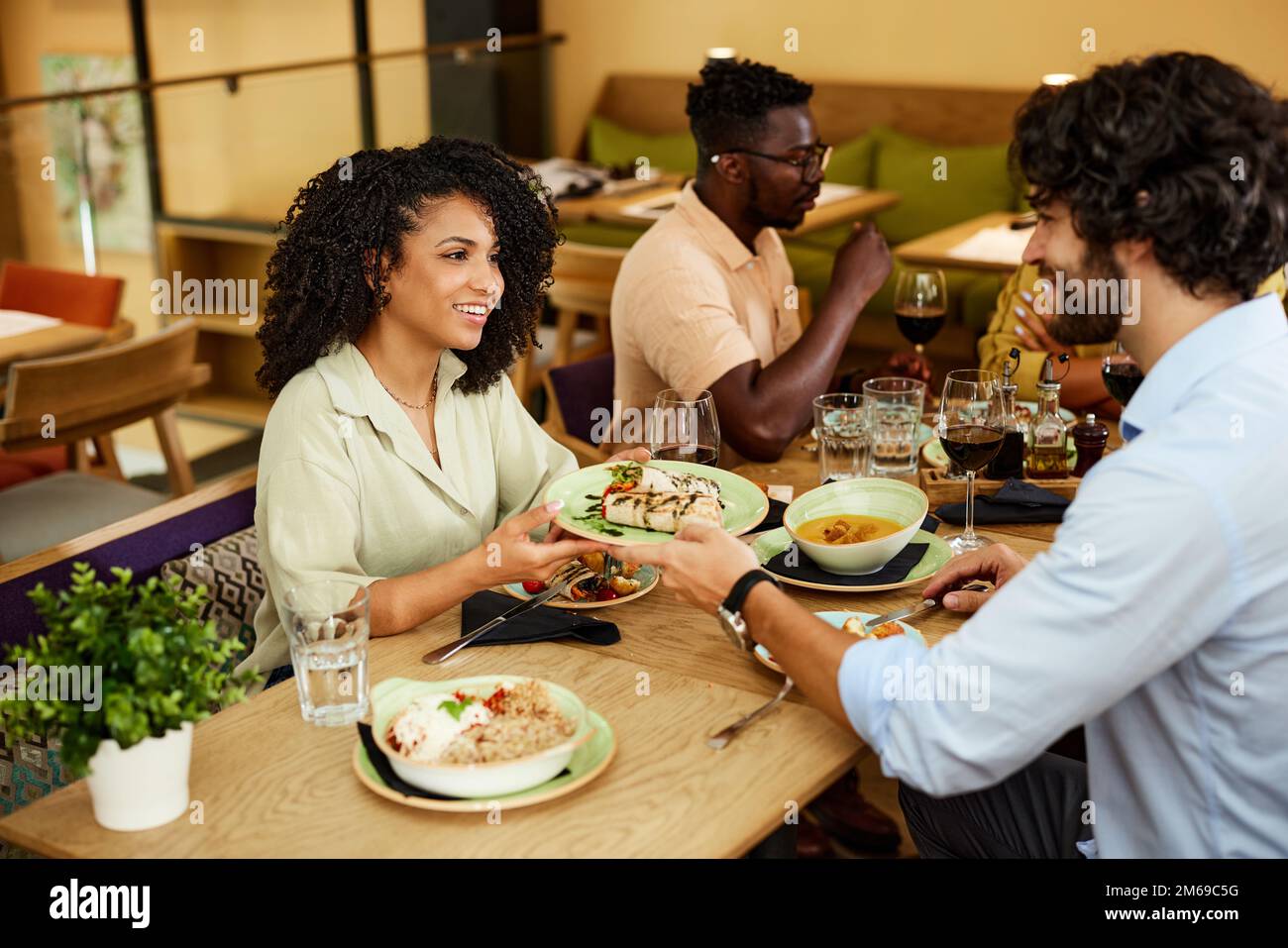 Ein multikultureller Freund isst mit Freunden in einem Restaurant. Stockfoto