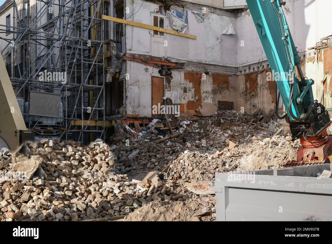 Zerstörtes Haus. Ein Bagger zerstört ein Haus mit einem Eimer. Stockfoto