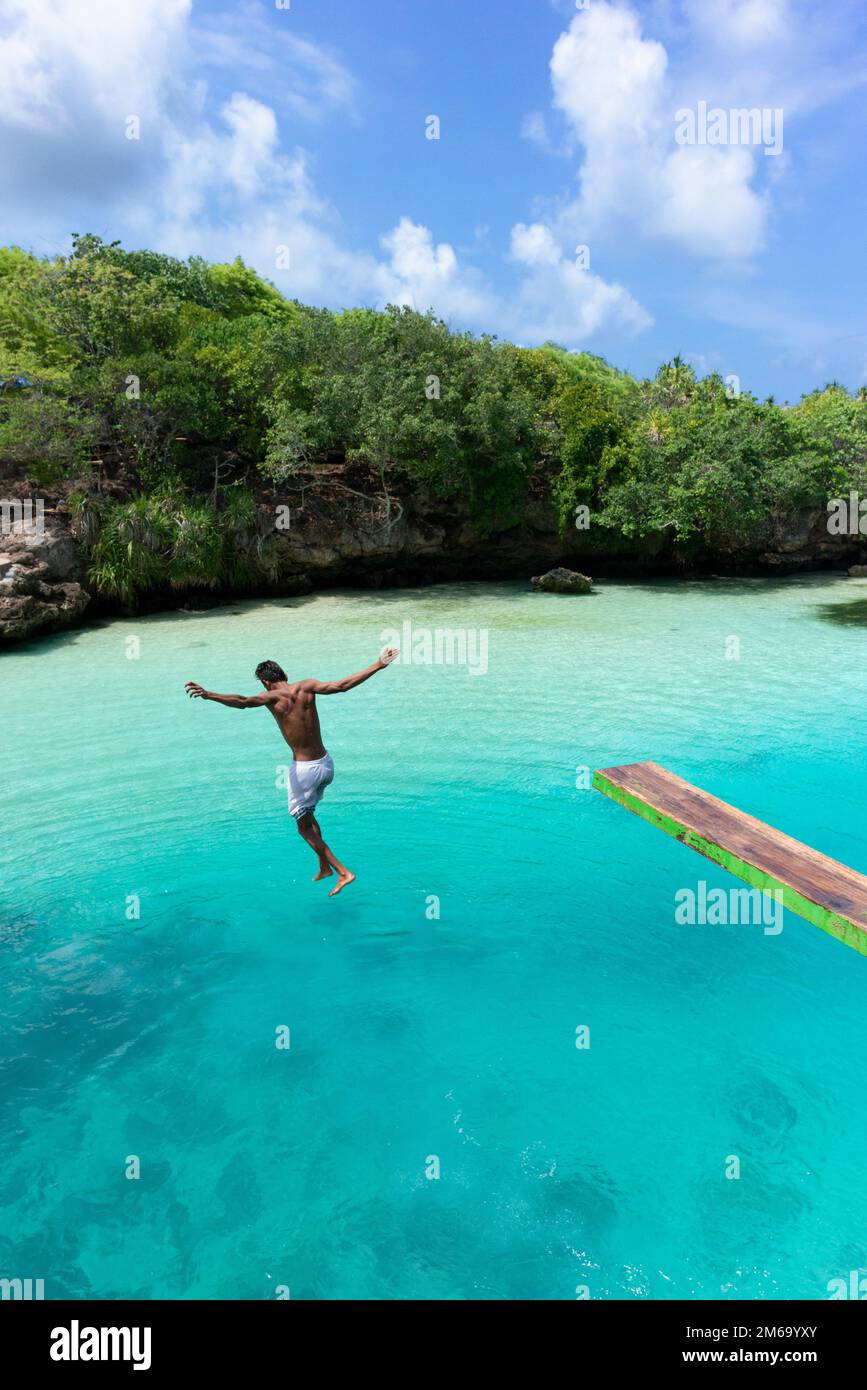 Ein junger Einheimischer springt in den Weekuri Lake, eine vom Ozean gespeiste Lagune. Stockfoto