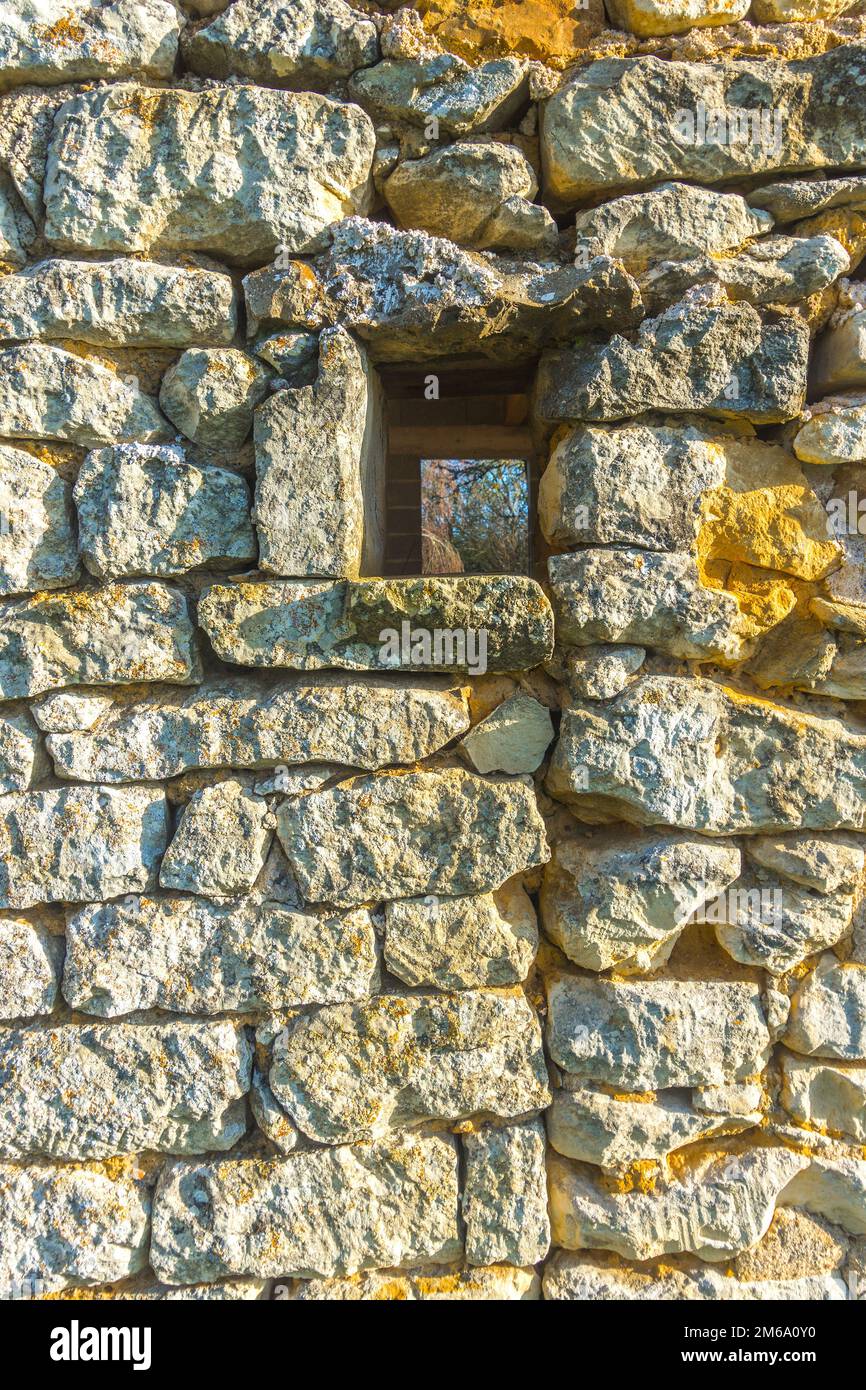 Strukturierte Steinarbeiten an der ausgefüllten Tür einer alten Scheune, Baumdekorationen auf dem Marktplatz, sud-Touraine, Frankreich. Stockfoto