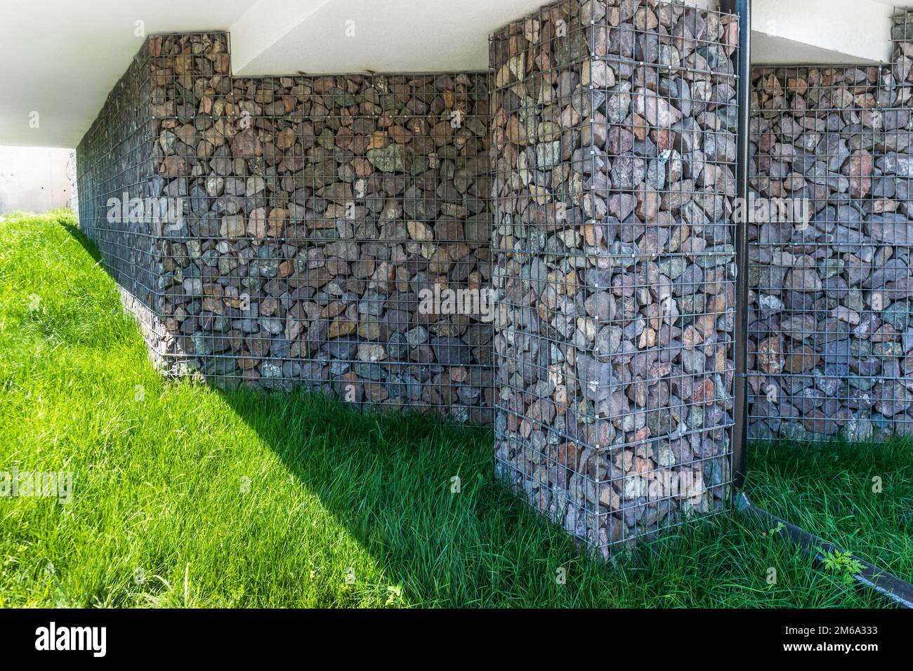 Gabionen bei der Fertigstellung der Fundamente eines Landhauses. Naturstein in der Fassadendekoration Stockfoto
